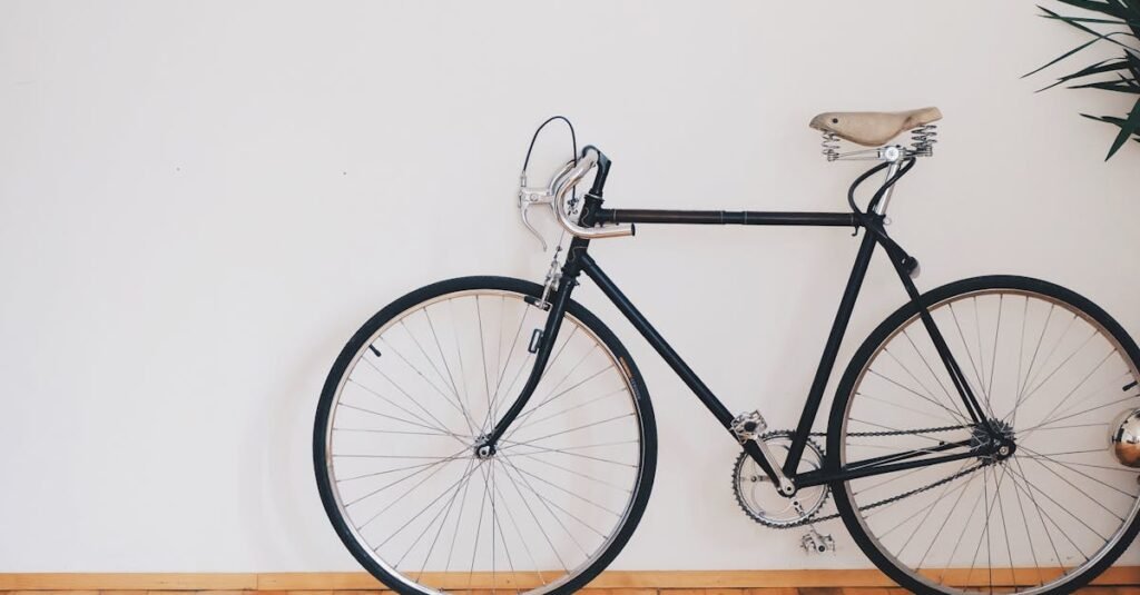A vintage-style bicycle leaning against a clean white wall with wooden flooring, emphasizing minimalist design.