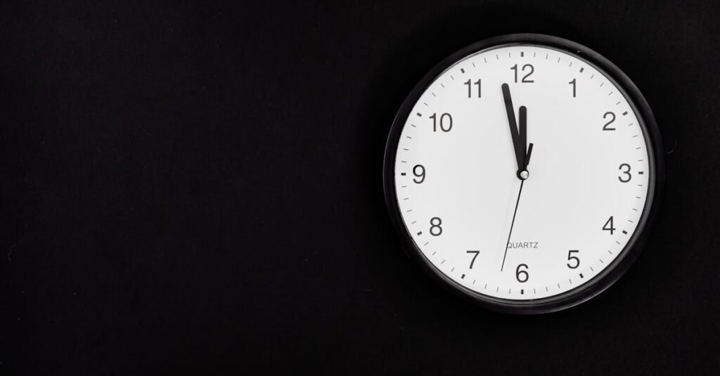 A simple wall clock set at midnight on a black background, ideal for business or time-related concepts.